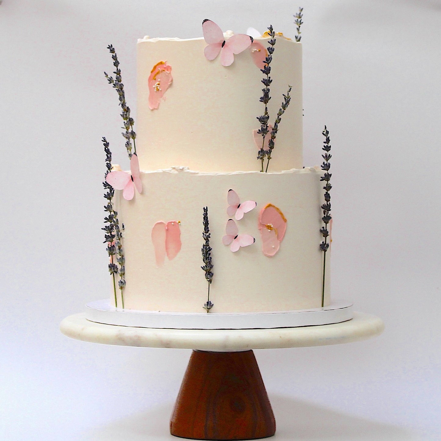 Two-tier cake with floral decorations on a white background